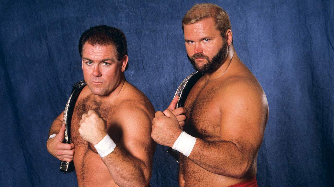 With their fists up in gesture, The Brain Busters hold the WWF World Tag Team title belts.