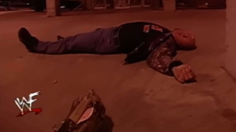 Steve Austin lays prone on the concrete after being struck by a car.