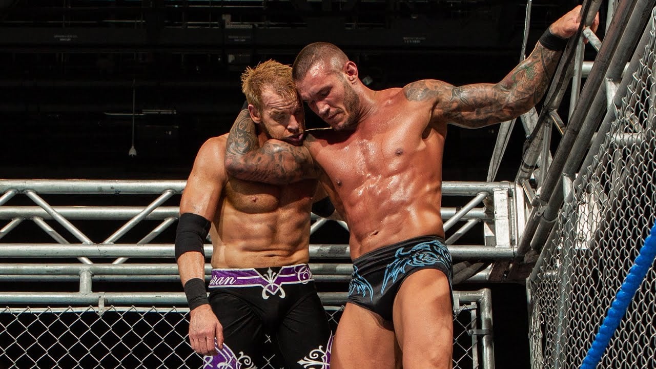 Randy Orton positions Christian for an RKO from the top rope inside a steel cage.