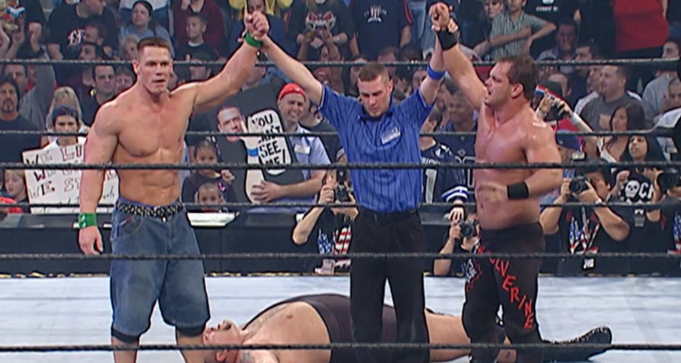 Chris Benoit and John Cena have their hands raised after winning.