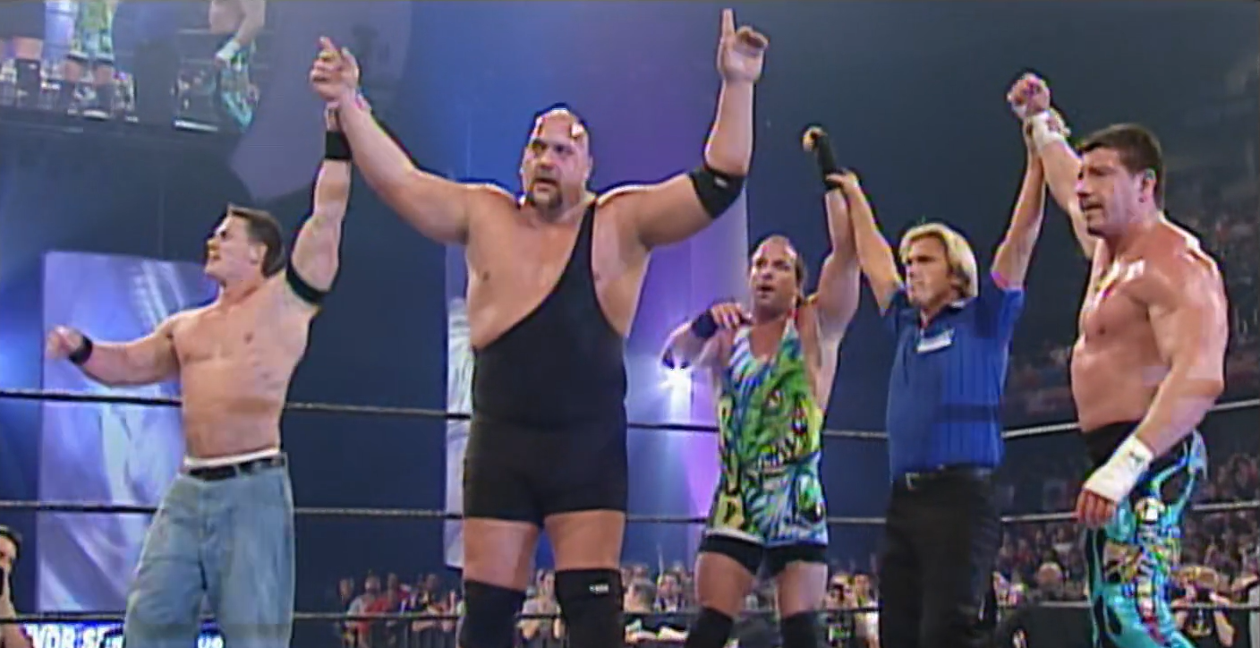 The faces have their hands raised, (left to right): John Cena, Big Show, Rob Van Dam, Eddie Guerrero.