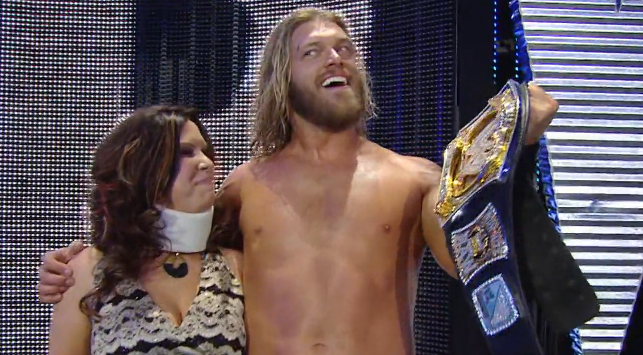 Edge gives a cheeky smile as he relishes his world title; Vickie Guerrero is at his side.