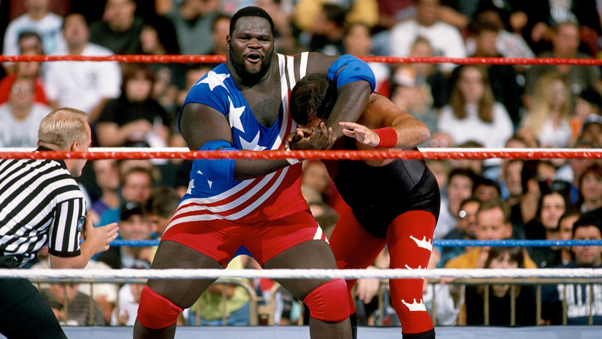 In a star-spangled attire, Mark Henry applies a headlock on Jerry Lawler.