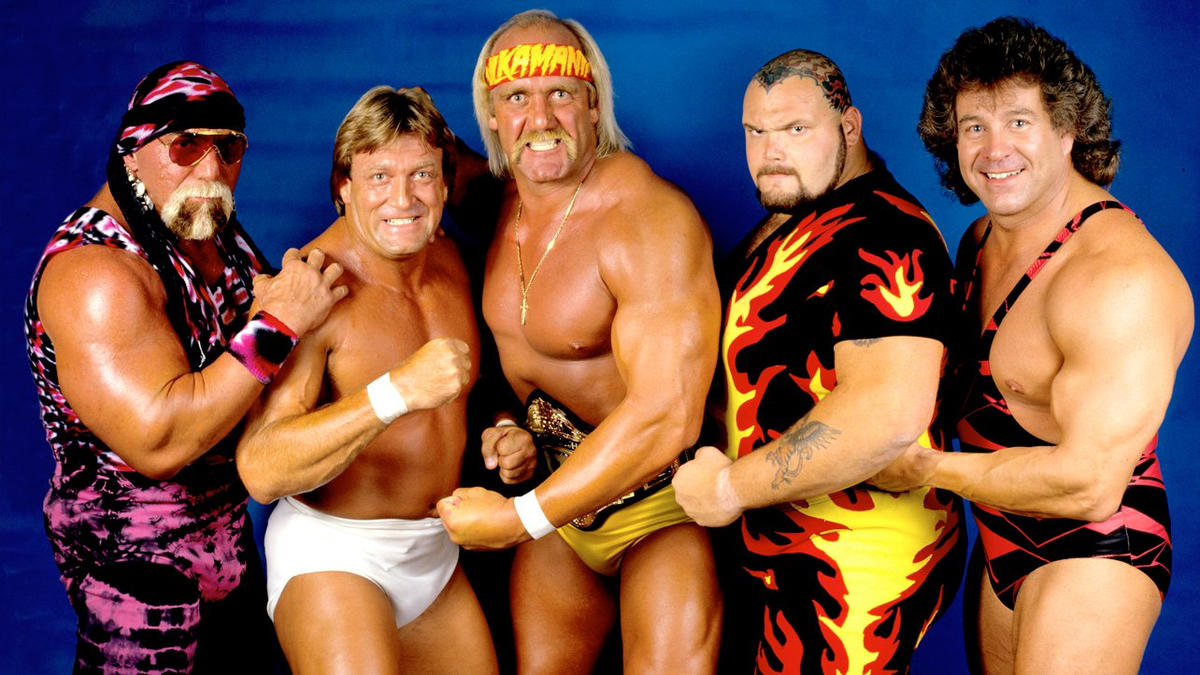 A backstage photo of Hogan's team, with a pink and black, bandana-wearing Graham on the far-left.